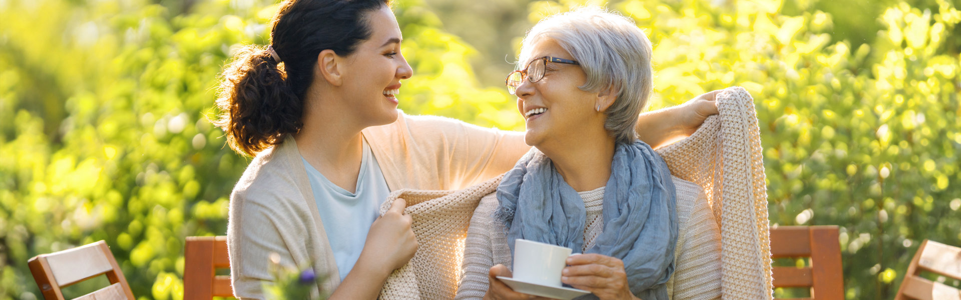 caregiver putting knitted blanket on her patient