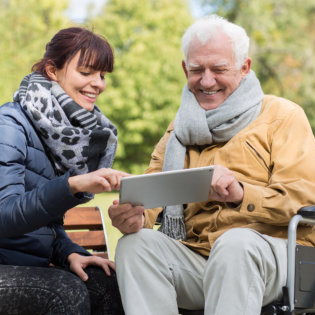 smiling patient together with his caregiver at the park