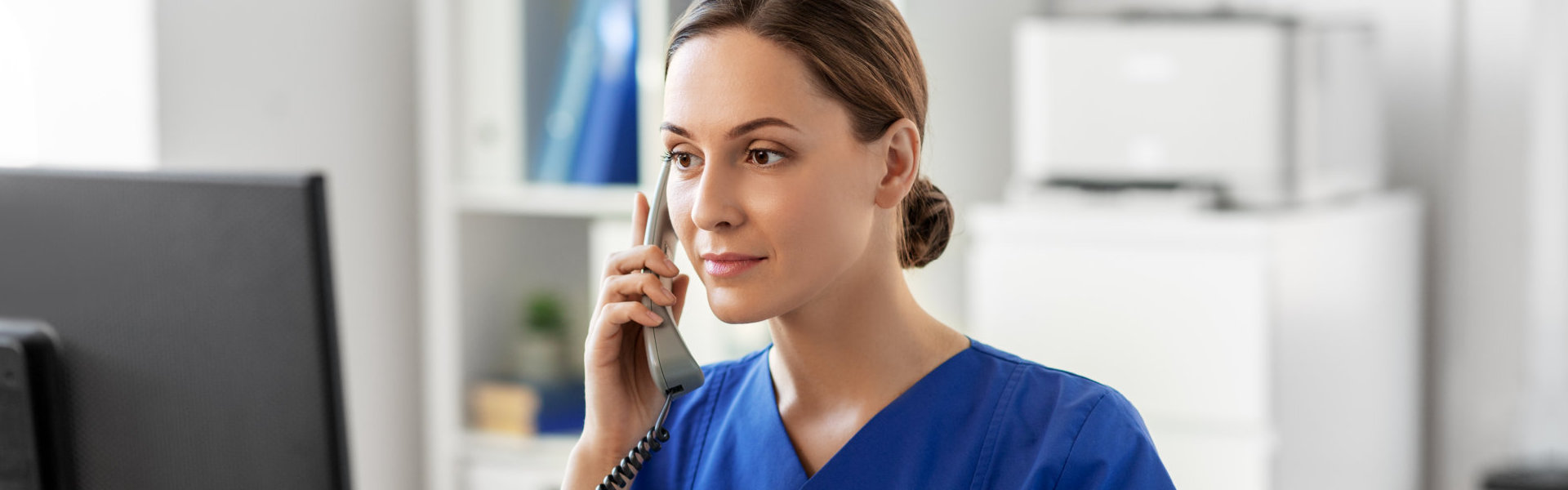 female doctor or nurse with computer calling on phone at hospital